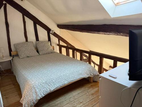 a bedroom with a bed and a tv in a room at historique in Clamecy