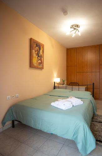 a bedroom with a green bed with towels on it at The 5th floor in Florina