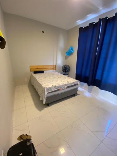 a bedroom with a bed and a blue curtain at Casa Temporada Trairi in Trairi