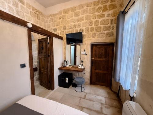 a room with a bed and a mirror and a door at Sümerler Konağı in Mardin