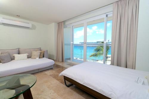 a bedroom with two beds and a view of the ocean at Hotel Casa Bahía Cozumel - Adults Only in Cozumel