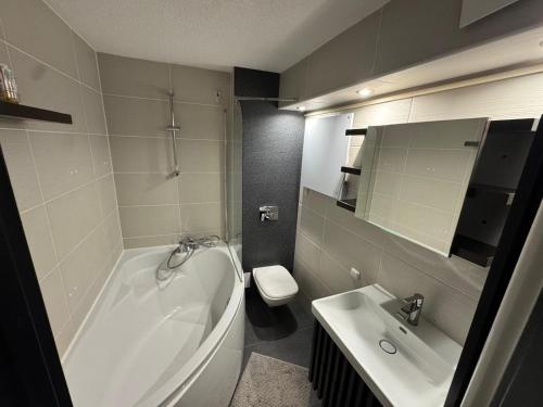 a bathroom with a tub and a toilet and a sink at Apartament Alan in Kłodzko