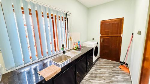 a kitchen with a sink and a washing machine at Asmi Villa in Jaffna