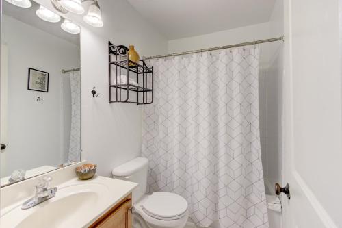 a bathroom with a toilet sink and a shower curtain at Jolly Jefferson Ave Walk to the Best of Midtown in Memphis