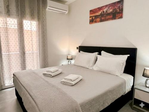 a bedroom with a bed with two towels on it at Kilada Luxury Apartment 1 in Kilada