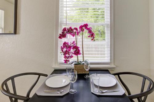 a table with two chairs and a vase with purple flowers at Jolly Jefferson Ave Walk to the Best of Midtown in Memphis