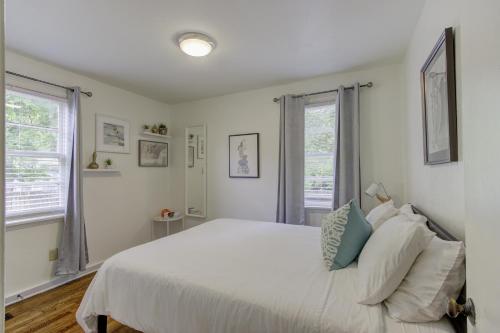 a bedroom with a white bed and two windows at Jolly Jefferson Ave Walk to the Best of Midtown in Memphis