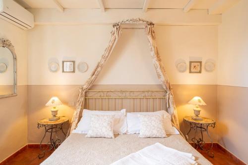 a bedroom with a canopy bed with two tables at Il Nido Di Anna in San Gimignano