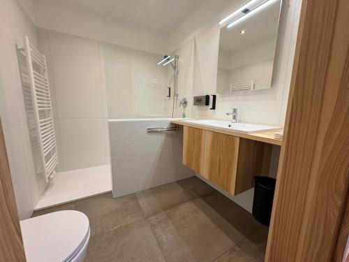 a bathroom with a sink and a toilet and a mirror at Pension Göschlberger in Mondsee