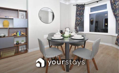 a dining room with a table and chairs and a mirror at Elm House by YourStays - Lovely home in Cheshire, quiet residential street in Crewe