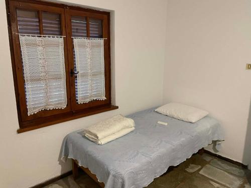 a small bed in a room with a window at Panagopoulos House in Agios Ioannis Pelio