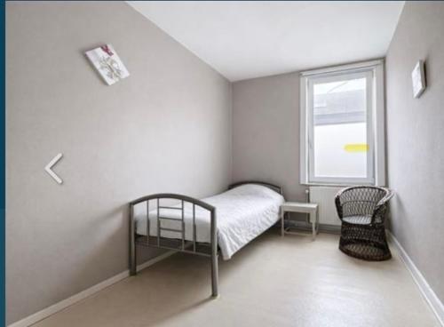 a small bedroom with a bed and a window at Zenitude in Jumet