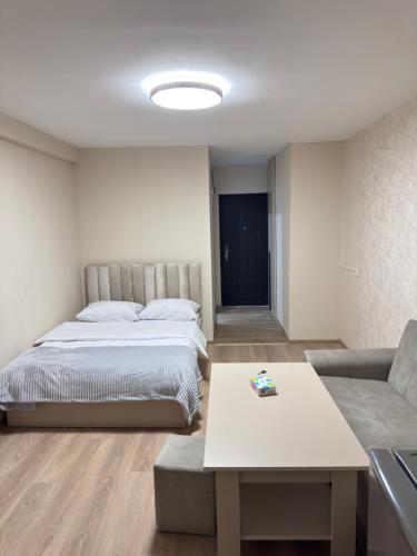 a bedroom with a bed and a couch and a table at MN apartment in Yerevan in Yerevan