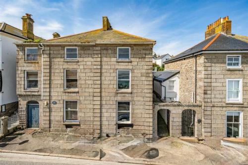 an old brick house on the side of a street at Minster Panorama & Minster Vista - - UNBROKEN BEACHFRONT VIEWS - - TWO STUNNING GEORGIAN HOUSES THAT CONNECT - - PRIVATE PARKING - - Beautifully Refurbished MARCH 2026 in St Ives