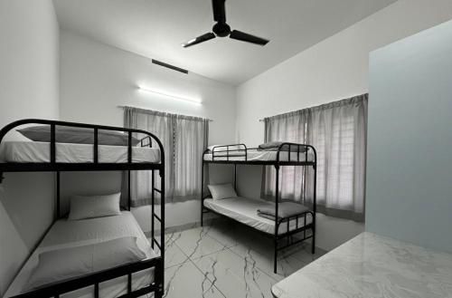 a room with two bunk beds and a ceiling fan at Cozstel in Kozhikode