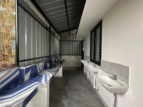 a public bathroom with sinks and mirrors and windows at Cozstel in Kozhikode