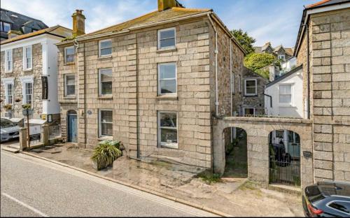 an old brick house on a city street at Minster Panorama & Minster Vista - - UNBROKEN BEACHFRONT VIEWS - - TWO STUNNING GEORGIAN HOUSES THAT CONNECT - - PRIVATE PARKING - - Beautifully Refurbished MARCH 2026 in St Ives