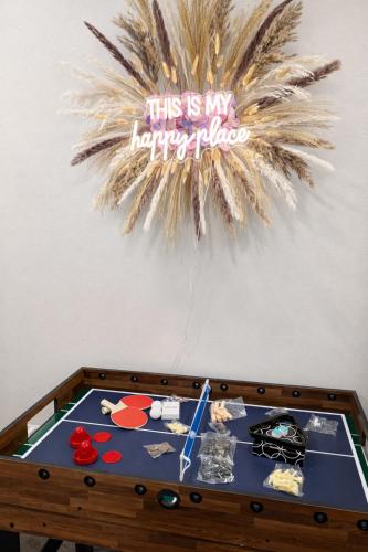 a ping pong table with a happy birthday sign on a wall at Cozy Spokane Apt in Spokane