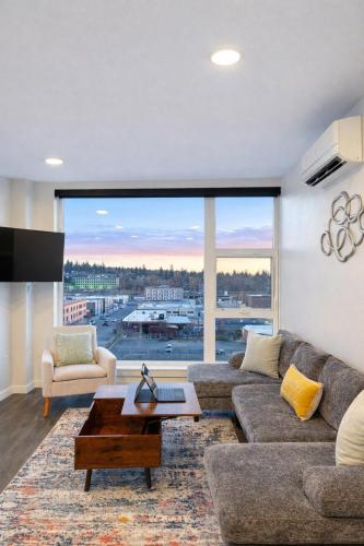 a living room with a couch and a large window at Cozy Spokane Apt in Spokane