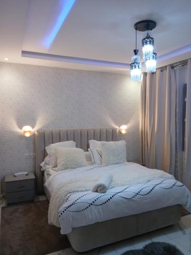 a bedroom with a large white bed with two pillows at Résidence ABOMO'S in Kribi