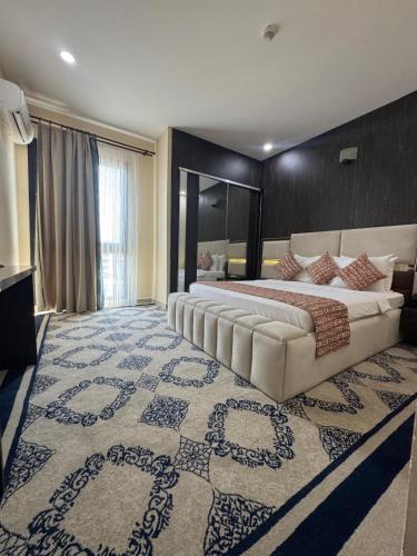 a large bedroom with a large bed and a large rug at Hôtel La Pivoine in Abidjan