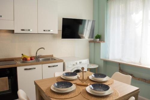 a kitchen with a table with four plates on it at Velaria Apartment in Termoli