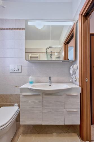 a bathroom with a sink and a toilet and a mirror at Venice Vacation in Marghera