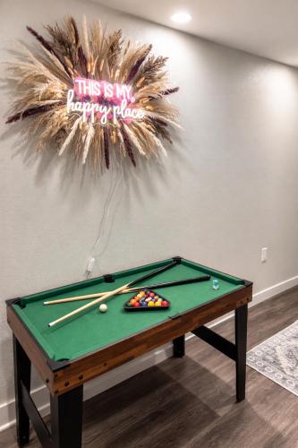 a pool table with cue balls and a sign on a wall at Cozy Spokane Apt in Spokane