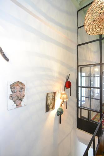 a white wall with paintings and a lamp on it at Dar Antonia in Sousse
