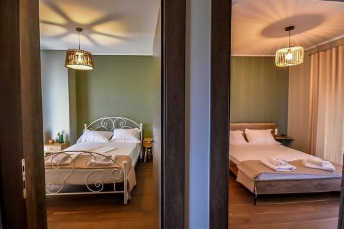 a bedroom with two beds and two lamps and a mirror at Thea Hill in Kritharia
