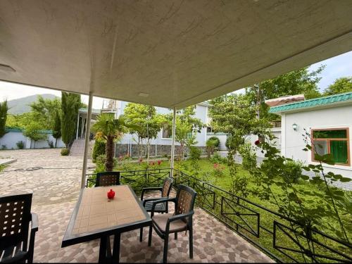 a patio with a table and chairs and a garden at Qebele hot pool in Gabala