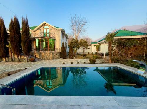 a swimming pool in front of a house at Qebele hot pool in Gabala