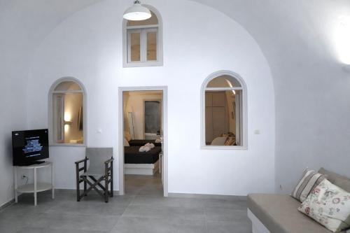 a living room with a couch and two windows at Yposkafo Suites - Villa - Santorini in Fira