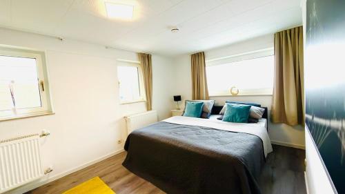 a bedroom with a large bed with blue pillows at Miras Guesthouse Ferienwohnung in Lengerich