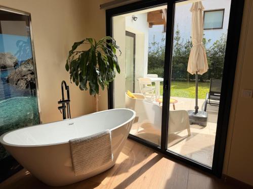 a bathroom with a large tub and a patio at Las Mareas de Llanes in Andrín