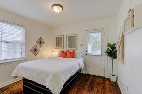 a bedroom with a bed with white sheets and orange pillows at Gated Cottage Community! Ideal Midtown Spot in Memphis