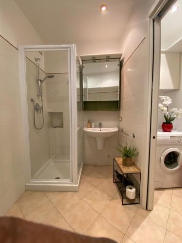a bathroom with a shower and a sink and a washing machine at Lacasadeitati in Lecco
