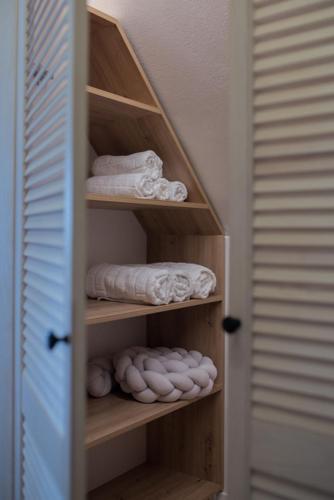 a closet with wooden shelves with towels and towels at Willa Widokowe Wzgórze in Falsztyn