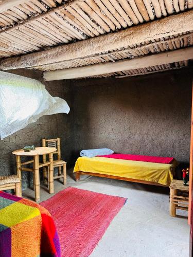 a room with two beds and a table with a table at El hada de Yumbilla in Cuispes