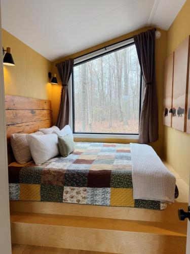 a bedroom with a bed with a large window at Bison Farm - Cabin Brisa in Culpeper