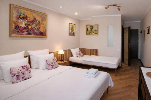 a hotel room with two beds and a couch at Hotelik Zielonka in Zielonka