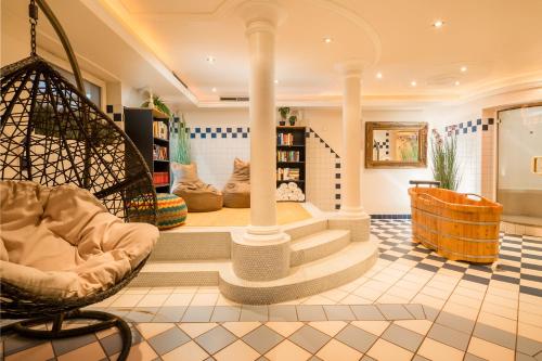 a living room with a spiral staircase and a chair at Hotel Standlhof Zillertal in Uderns