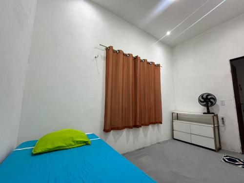 a bedroom with a blue bed and a curtain at Residencial Lourenço - Vila Preá in Cruz