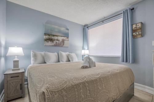 a bedroom with a large bed with a window at Carolina Reef #705 in Myrtle Beach