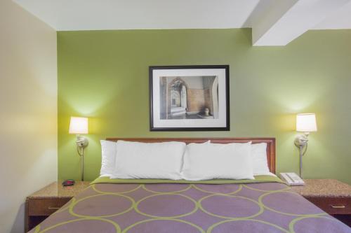 a bedroom with a bed with green walls and two lamps at Super 8 by Wyndham Jasper in Jasper