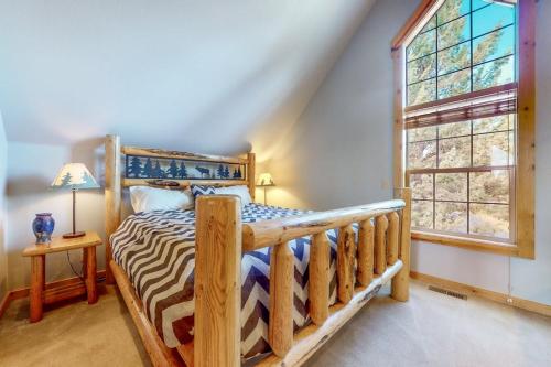 a bedroom with a wooden bed and a window at Eagle Creek Chalet on the Pond in Redmond