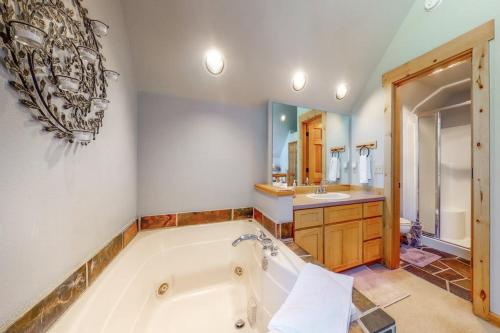 a large bathroom with a tub and a sink at Eagle Creek Chalet on the Pond in Redmond