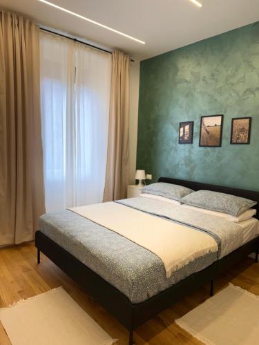 a bedroom with a bed and a green wall at Stay & Solution Apartment in Trieste