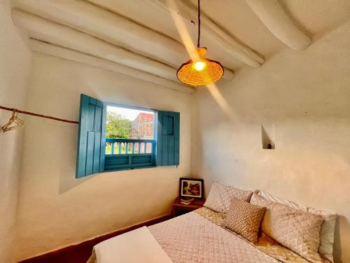 a bedroom with a bed and a window at Casa Quintanilla Barichara in Barichara