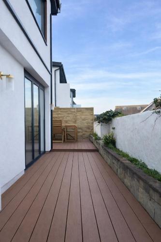 a wooden deck on the side of a house at Fabulous Ground Floor Apt Adjacent to Beach in Rhosneigr